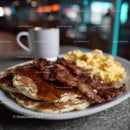Stack of Fluffy Pancakes with Bacon and Syrup in Cozy Breakfast Setting