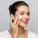 Beautiful Woman Applying Facial Moisturizer for Radiant Skin