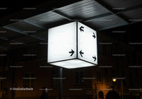 Illuminated directional cube sign at urban night scene