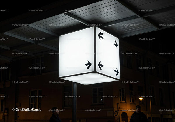 Illuminated directional cube sign at urban night scene JPG Mockup Image