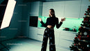 Young woman posing in modern kitchen near Christmas tree