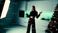 Young woman posing in modern kitchen near Christmas tree