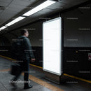 Man walking past empty illuminated advertising board underground