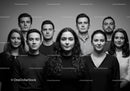 Serious young adults standing closely in black and white