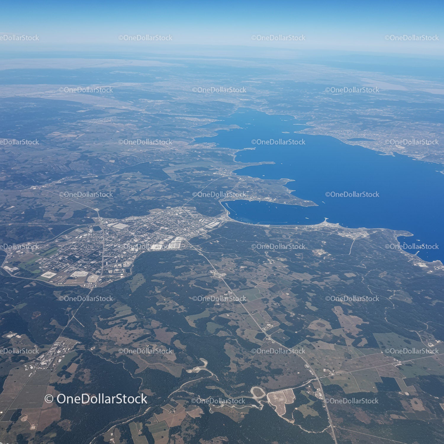 Widok z lotu ptaka na jezioro Blue Lake otoczone zielonym lasem i terenami wiejskimi