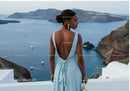 Elegant woman in blue dress overlooking sea cliffs