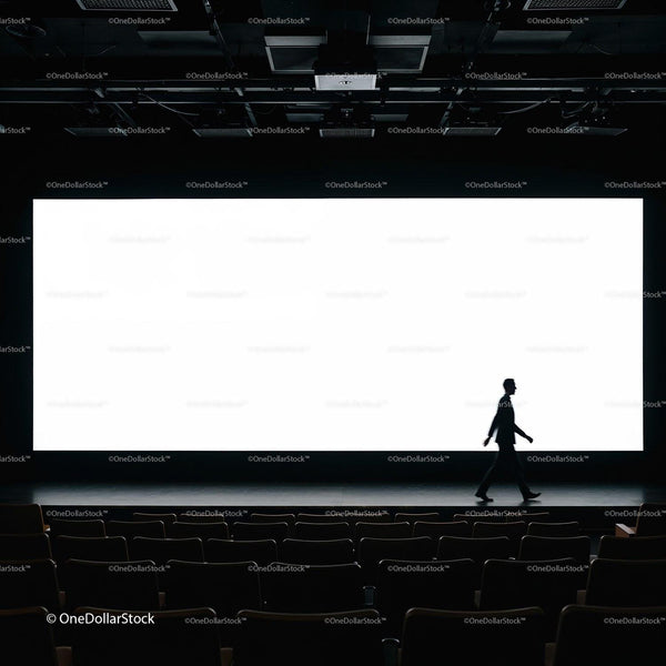 Silhouette of man walking in empty theater with bright screen JPG Mockup Image