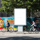 Urban street scene with blank billboard and cyclists