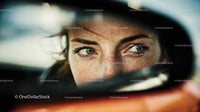 Close-up of Woman with Blue Eyes Looking in Car Rearview Mirror