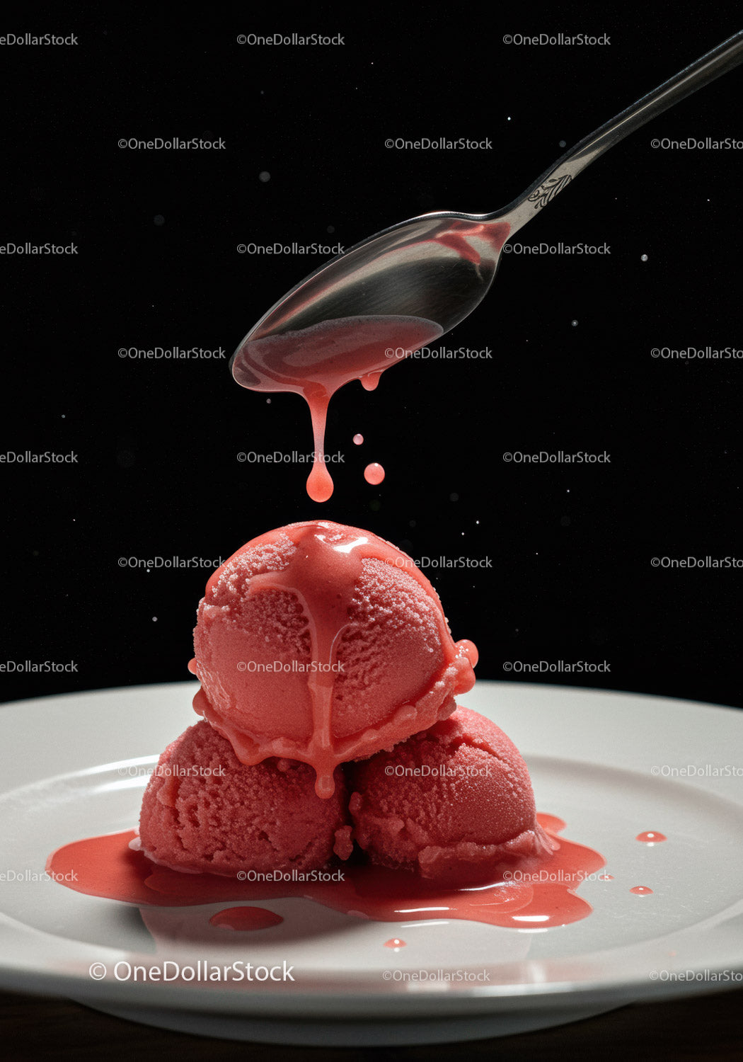 Red sorbet scoops with dripping sauce on white plate