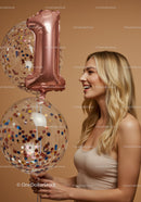 Smiling young woman celebrating with number one balloon