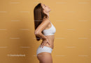 Confident Woman in White Sportswear Posing Against Warm Beige Background