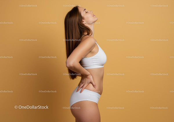 Confident Woman in White Sportswear Posing Against Warm Beige Background