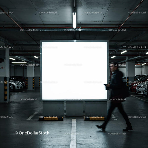 Man walking past illuminated billboard in parking garage JPG Mockup Image