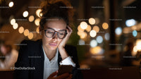 Young Woman Wearing Glasses Using Smartphone Amid Night City Lights