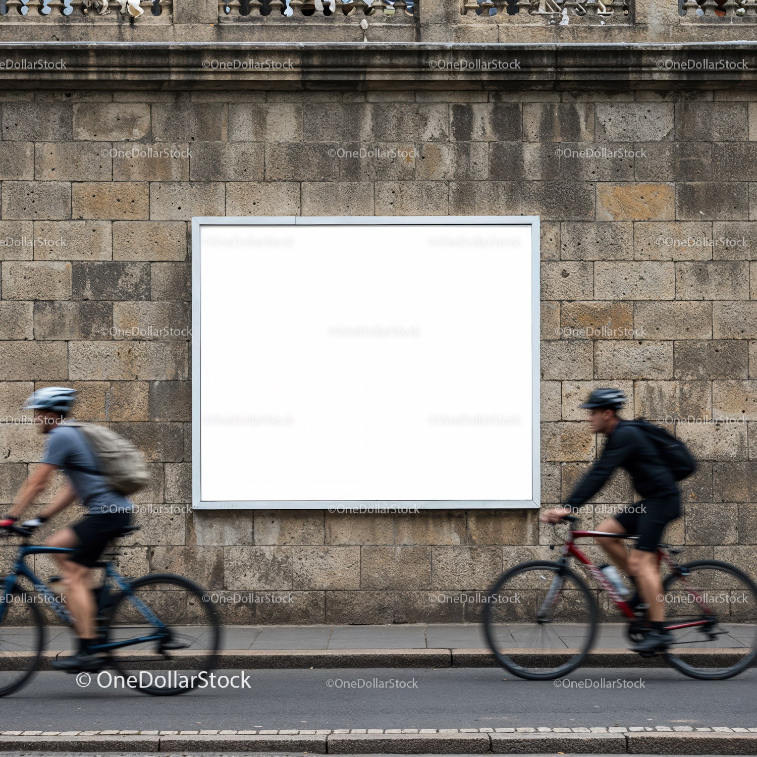 Two cyclists riding past blank urban billboard on stone wall