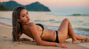 Beautiful Woman in Black Bikini Relaxing on Beach at Sunset
