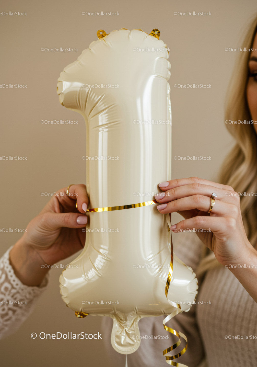 Hands Decorating Ivory Number One Balloon with Ribbon