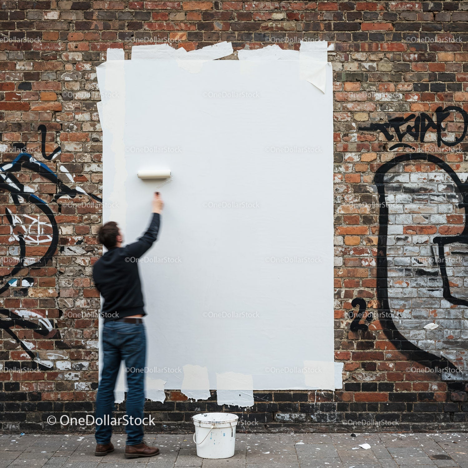 Mężczyzna malujący graffiti na miejskiej ścianie z cegły