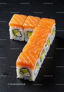 Fresh salmon avocado sushi rolls on black slate