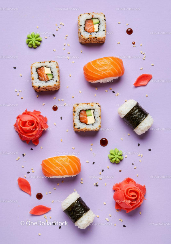 Colorful sushi assortment with garnishes on pastel background
