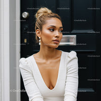 Elegant woman in white dress with pearl earrings outdoors