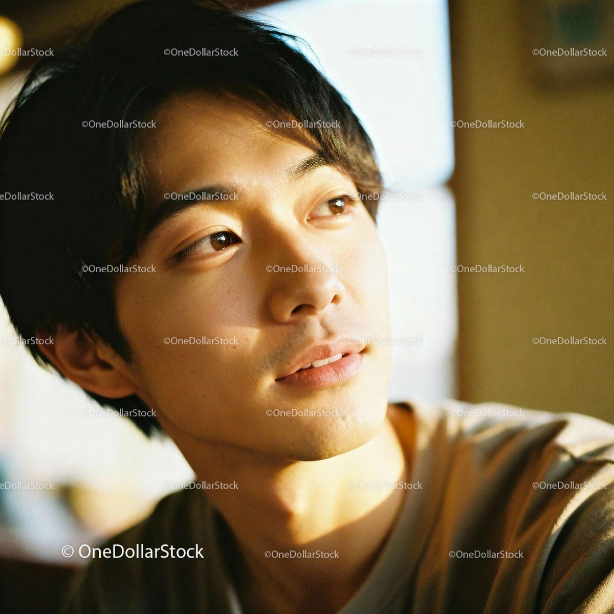Young man gazing thoughtfully in warm indoor light