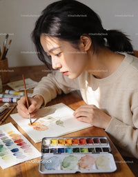 Young woman painting delicate floral watercolor art