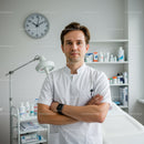 Confident Male Doctor Standing in Modern Medical Clinic