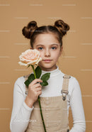 Young Girl Holding a Beautiful Pale Pink Rose Against Beige Background