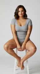 Young Woman Sitting on Stool in Casual Gray Outfit for Lifestyle Photography
