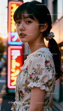 Young woman in floral dress under city neon lights