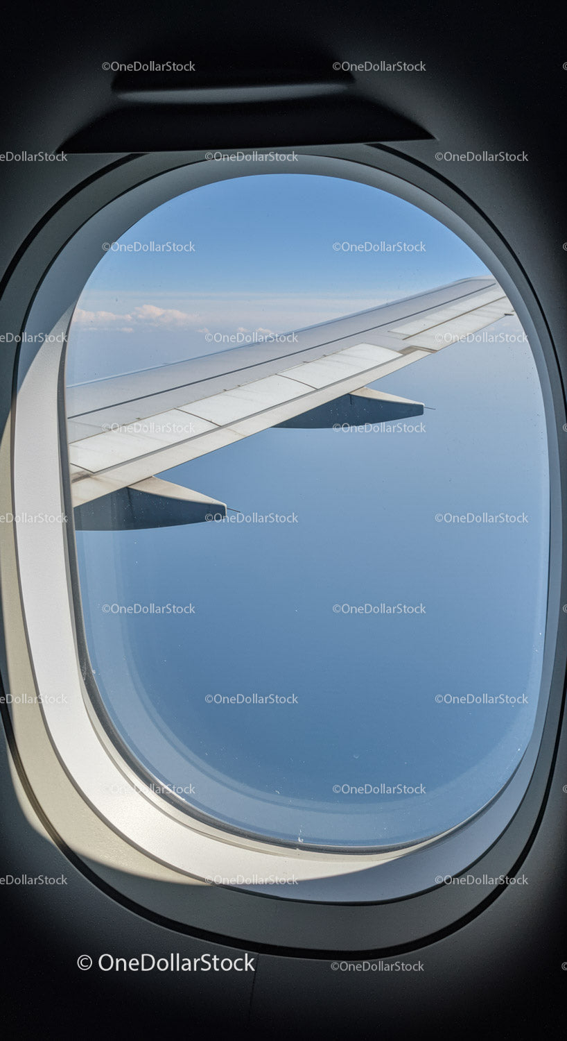 Airplane Wing and Sky View Through Aircraft Window in Flight