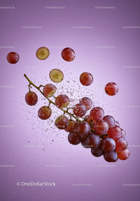 Fresh red grapes submerged in clear water splash