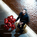 Man Holding Red Heart Balloons and Chocolates Outdoors