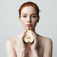 Portrait of a Woman with Red Hair Holding a Pear in Minimalist Studio Setting