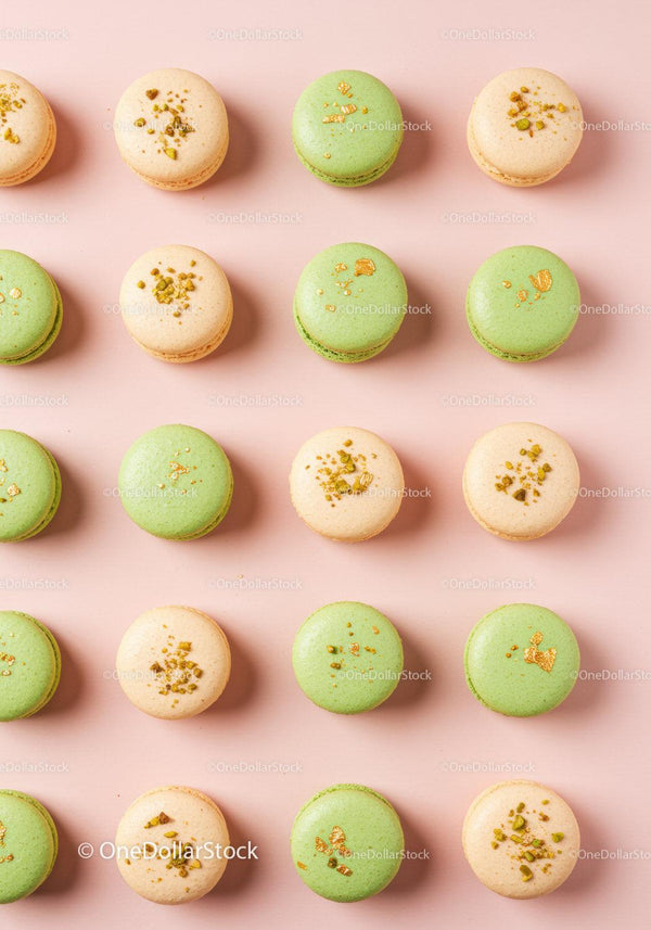 Assorted pistachio and vanilla macarons on pastel background