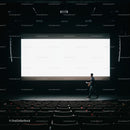 Man Walking Across Dark Theater Stage With Large Screen