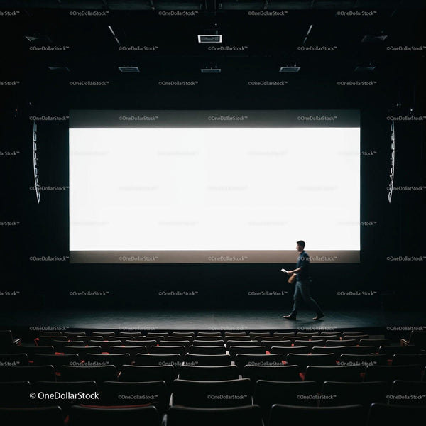 Man Walking Across Dark Theater Stage With Large Screen JPG Mockup Image