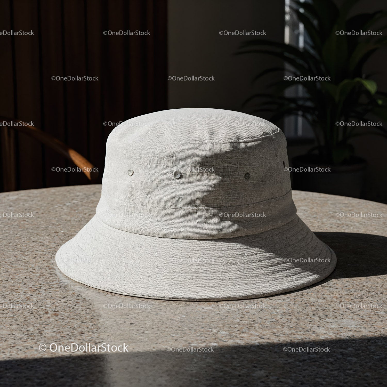 Minimalistyczny biały kapelusz typu bucket na kamiennym stole w naturalnym świetle