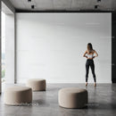 Woman standing in minimalist modern space with ottomans