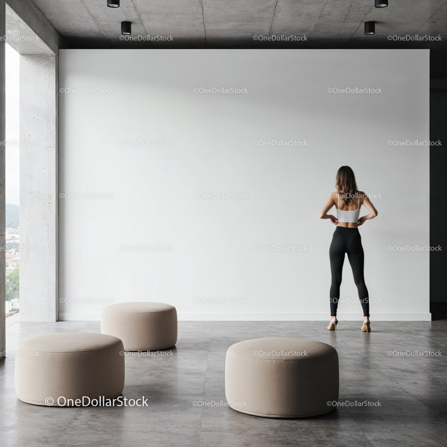 Woman standing in minimalist modern space with ottomans