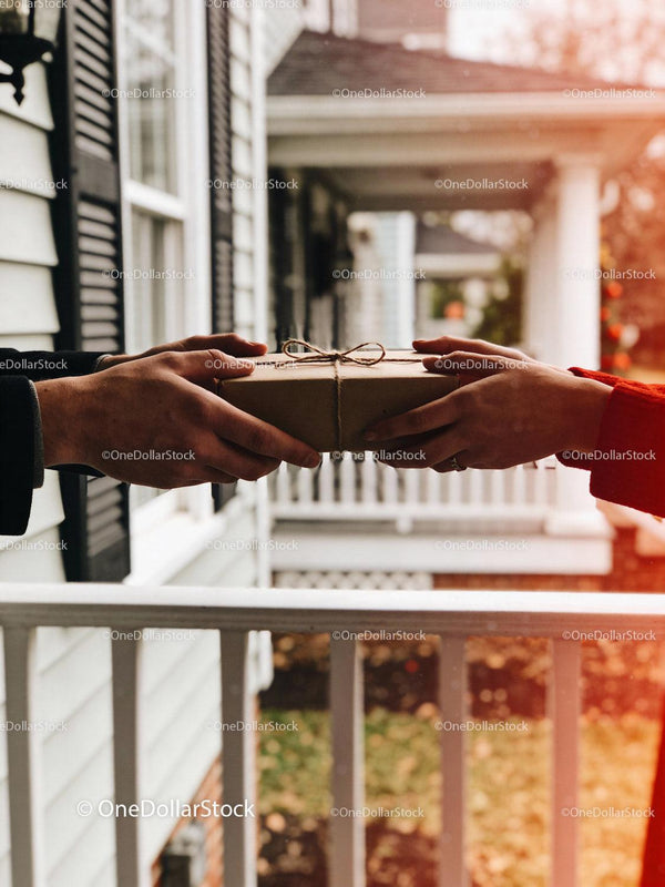 Couple exchanging a gift on porch with gentle sunlight