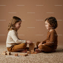 Two children playing with wooden blocks on carpet