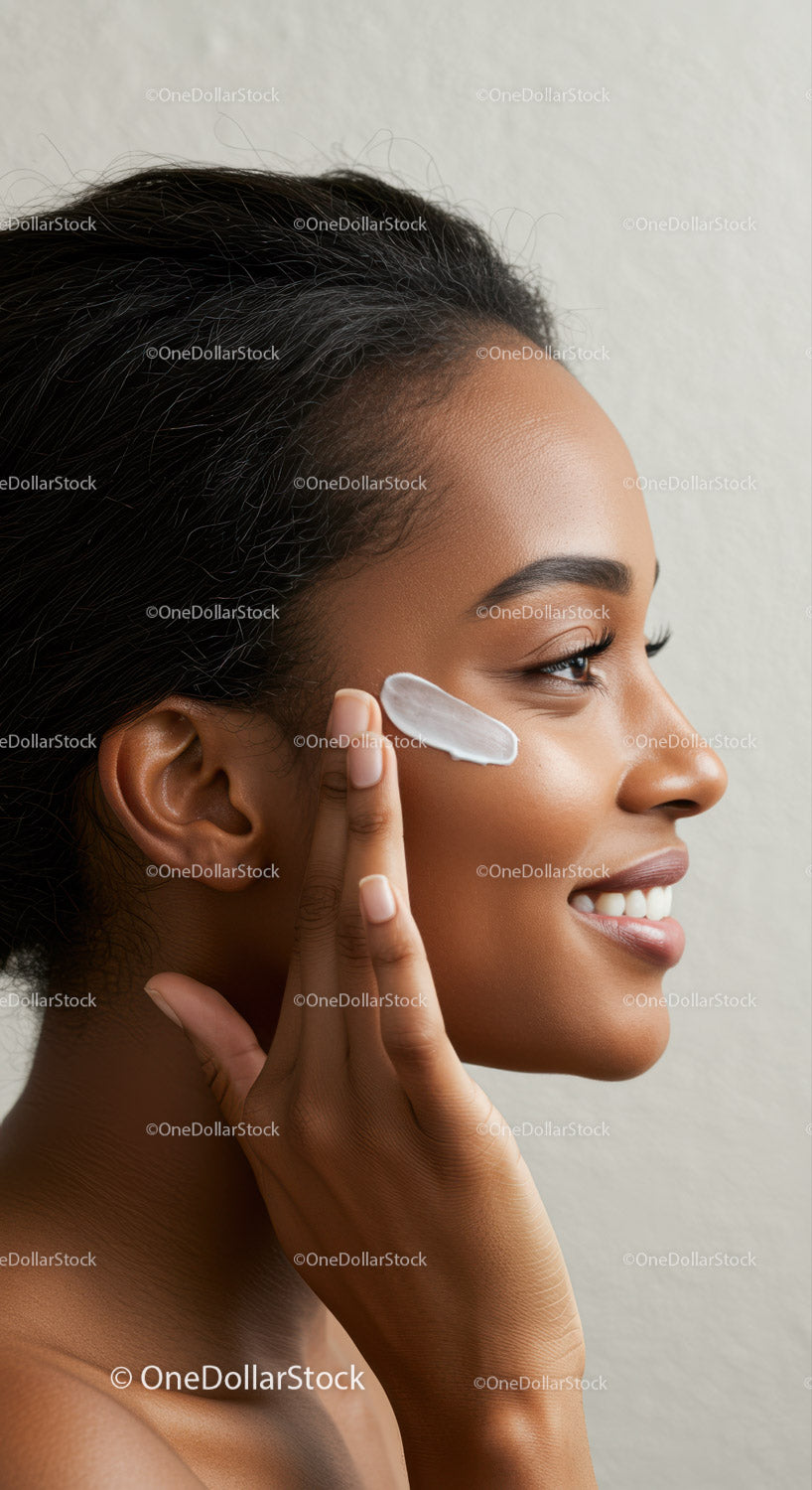 Close-up of a woman applying moisturizer to her face for skincare routine