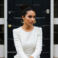 Elegant young woman in white dress sitting outdoors