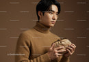 Young Man in Beige Turtleneck Sweater Holding Leather Clutch