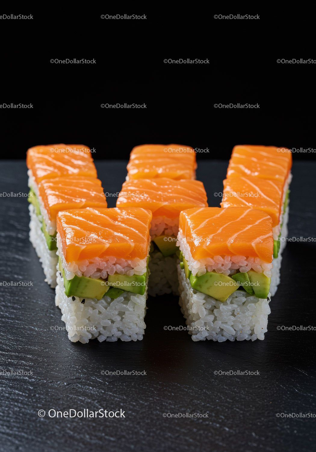Świeże kostki sushi z łososiem i awokado na czarnym łupku