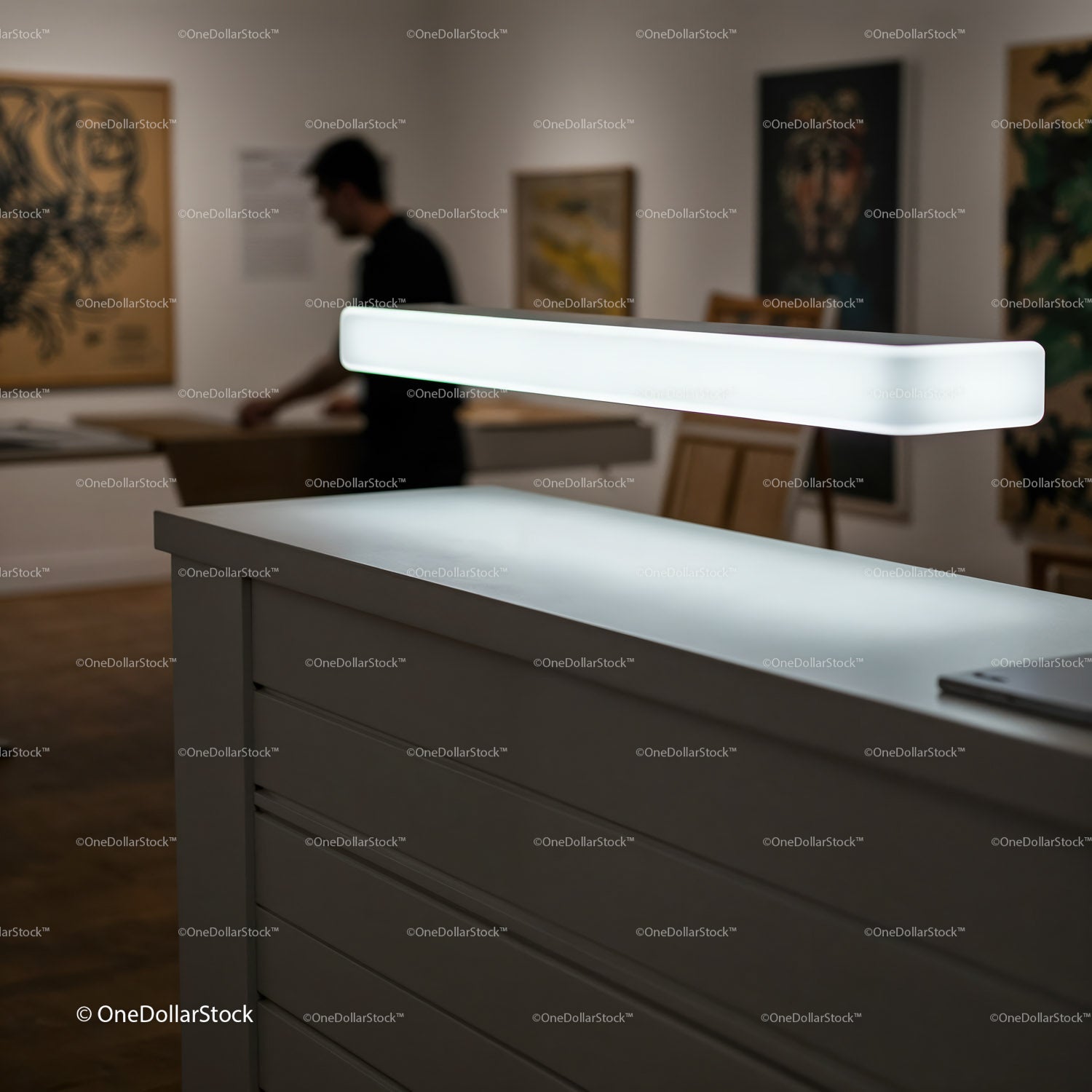 Modern white reception desk with illuminated lamp in gallery