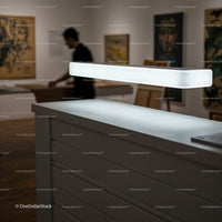 Modern white reception desk with illuminated lamp in gallery